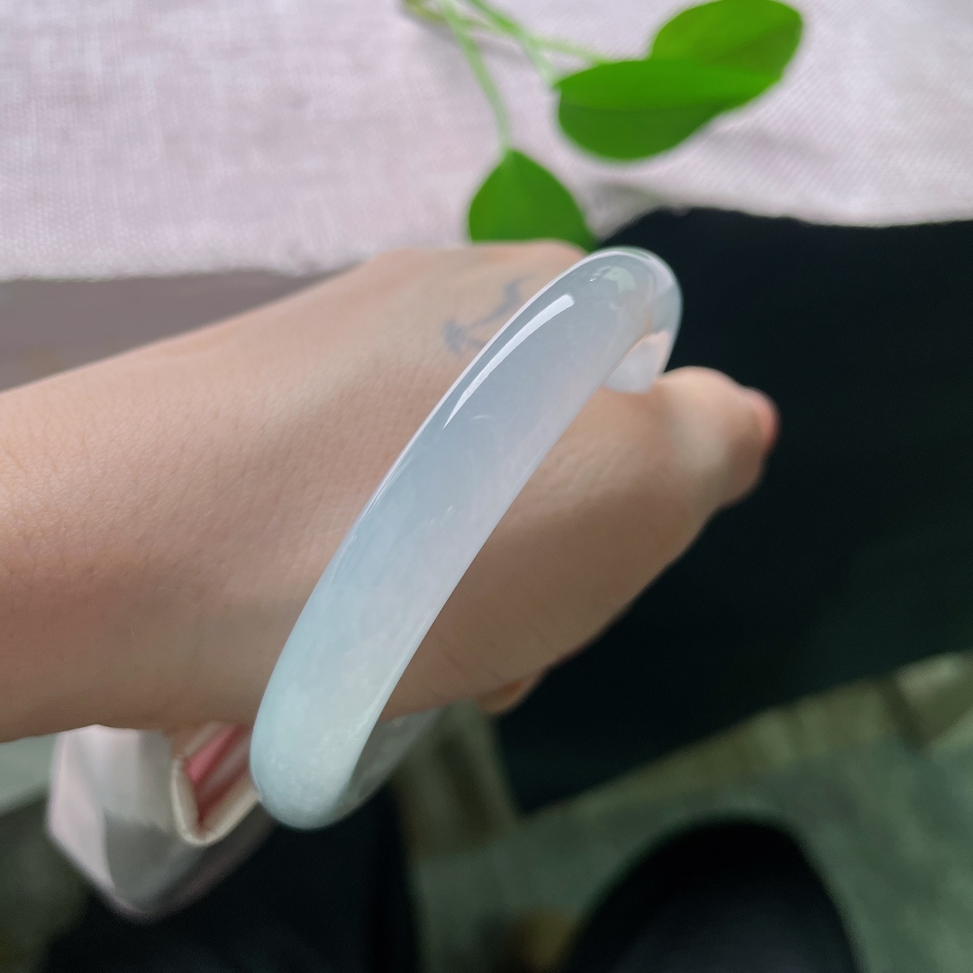 53.9/10.1，冰紫罗兰圆条，无裂，清透冰润玉底，几抹洒金错落散落腕间，恍若秋日金桂簌簌飘落，细碎黄花悄然绽于素玉之上，满腕皆是秋意。ss58074a