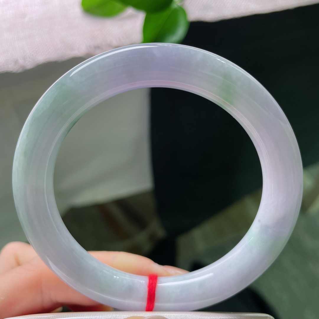 58/10，春彩圆条，一点裂，淡春底圆条玉镯，镯身弥漫一层淡淡的紫雾，浅浅揉入几分晴青底色，春韵温柔