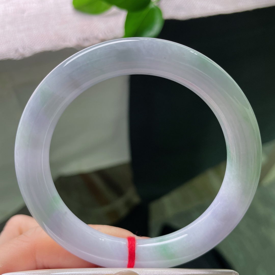 58/10，春彩圆条，一点裂，淡春底圆条玉镯，镯身弥漫一层淡淡的紫雾，浅浅揉入几分晴青底色，春韵温柔缱绻。ss57883a