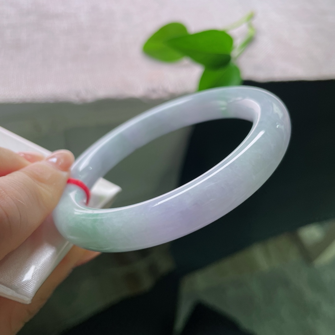 58/10，春彩圆条，一点裂，淡春底圆条玉镯，镯身弥漫一层淡淡的紫雾，浅浅揉入几分晴青底色，春韵温柔缱绻。ss57883a