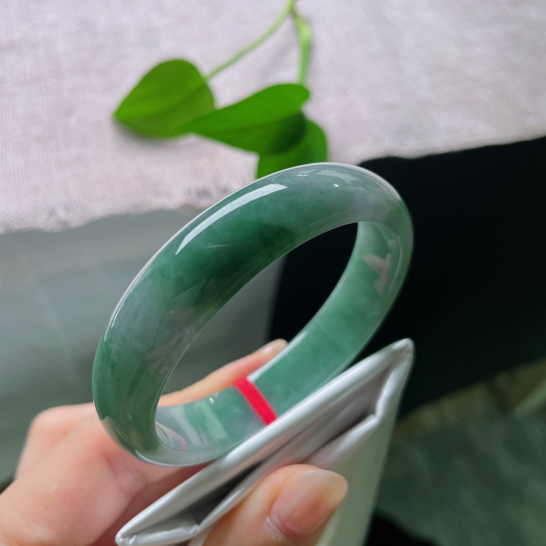油青贵妃，一点皮纹，冰润飘绿正圈平安镯，半圈是清透的冰种底质，翠色如烟如云，自然飘散于镯身。ss58020a