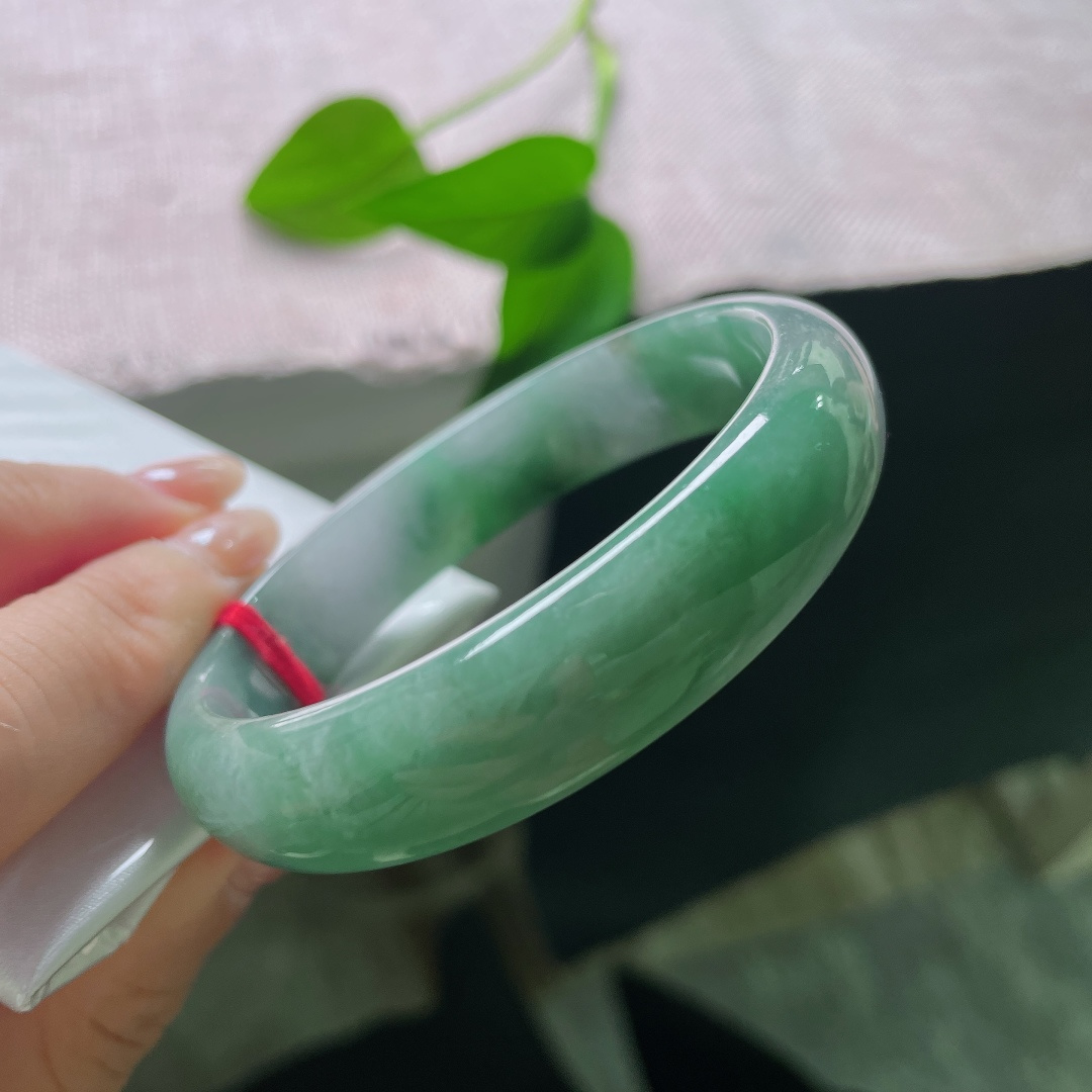 油青贵妃，一点皮纹，冰润飘绿正圈平安镯，半圈是清透的冰种底质，翠色如烟如云，自然飘散于镯身。ss58020a