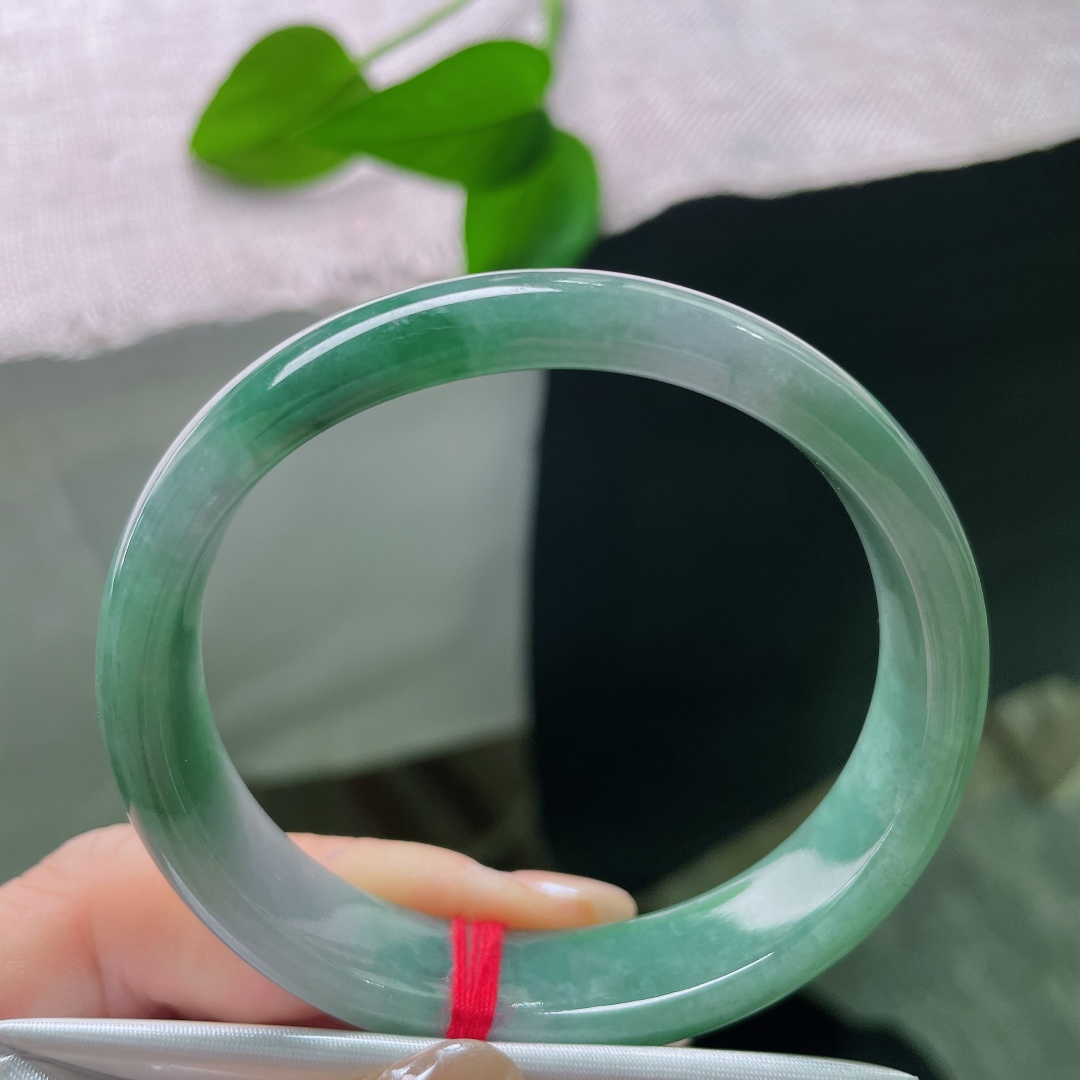 油青贵妃，一点皮纹，冰润飘绿正圈平安镯，半圈是清透的冰种底质，翠色如烟如云，自然飘散于镯身。ss58