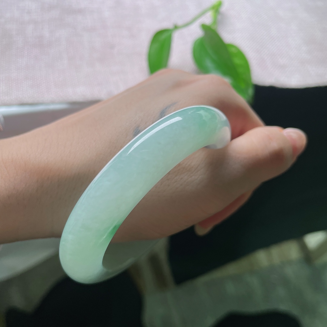 55/12.9/9.8，飘花正圈，有棉线，玉质温润细腻，柔光静静流淌，不似浓艳珠宝那般张扬，点点飘绿恰到好处，悄悄点亮整只镯子的灵气。ss58045a