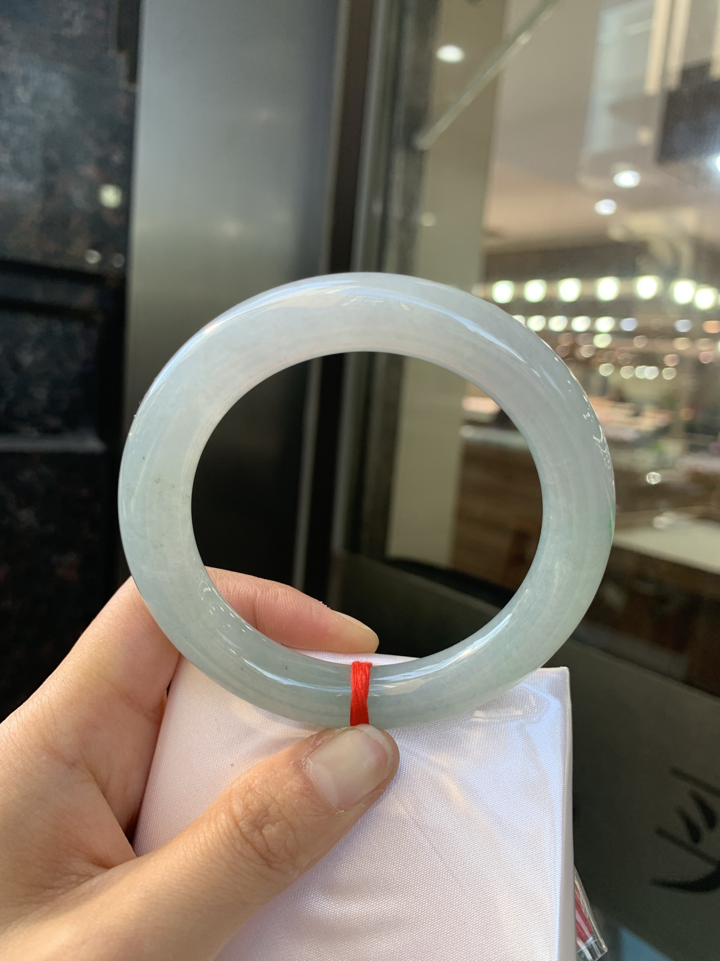 冰油圆条，打灯两处细纹，玉质冰润，油青底飘一小朵绿花，点睛之笔，彰显韵味