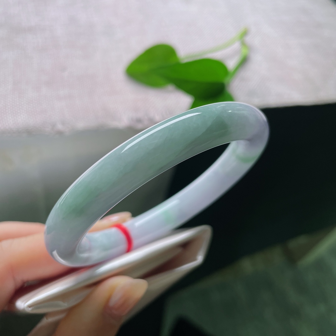 58/10，春彩圆条，一点裂，淡春底圆条玉镯，镯身弥漫一层淡淡的紫雾，浅浅揉入几分晴青底色，春韵温柔缱绻。ss57883a