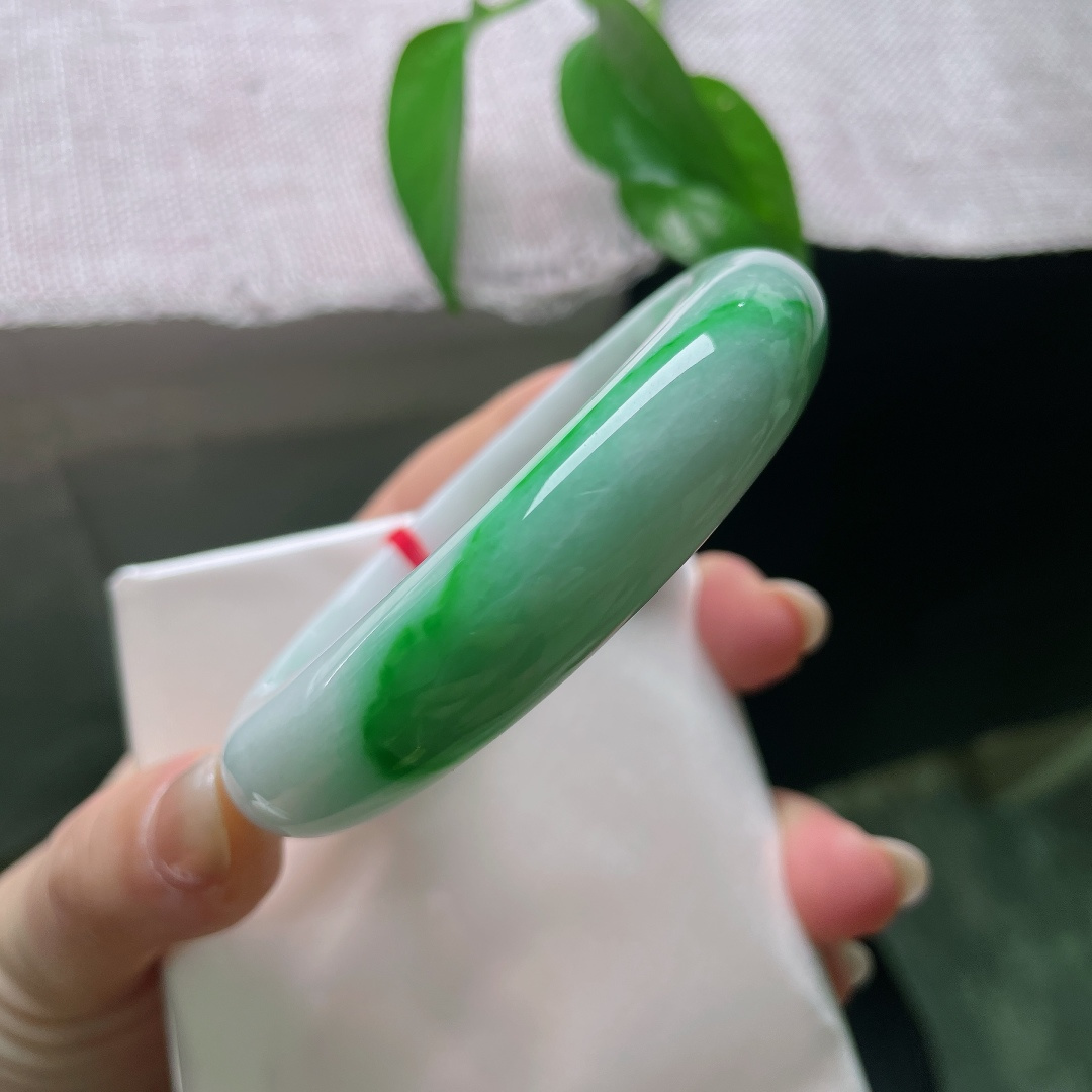 飘绿正圈，有纹，辣绿耀眼，冰润莹白玉底之上，一抹浓艳正阳绿沿镯身迤逦铺展，翠色浓郁鲜活，贵气天成。ss57988a