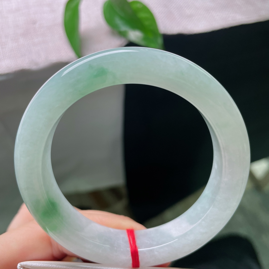 55/12.9/9.8，飘花正圈，有棉线，玉质温润细腻，柔光静静流淌，不似浓艳珠宝那般张扬，点点飘绿恰到好处，悄悄点亮整只镯子的灵气。ss58045a