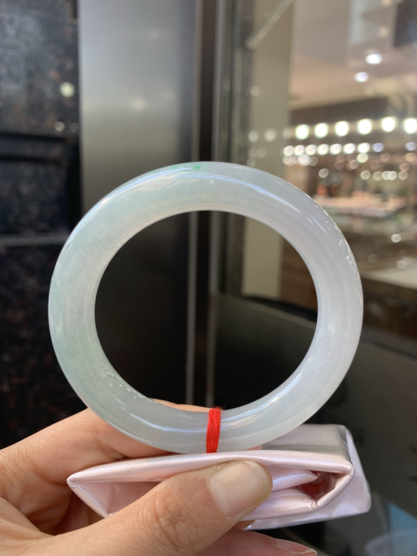 冰油圆条，打灯两处细纹，玉质冰润，油青底飘一小朵绿花，点睛之笔，彰显韵味