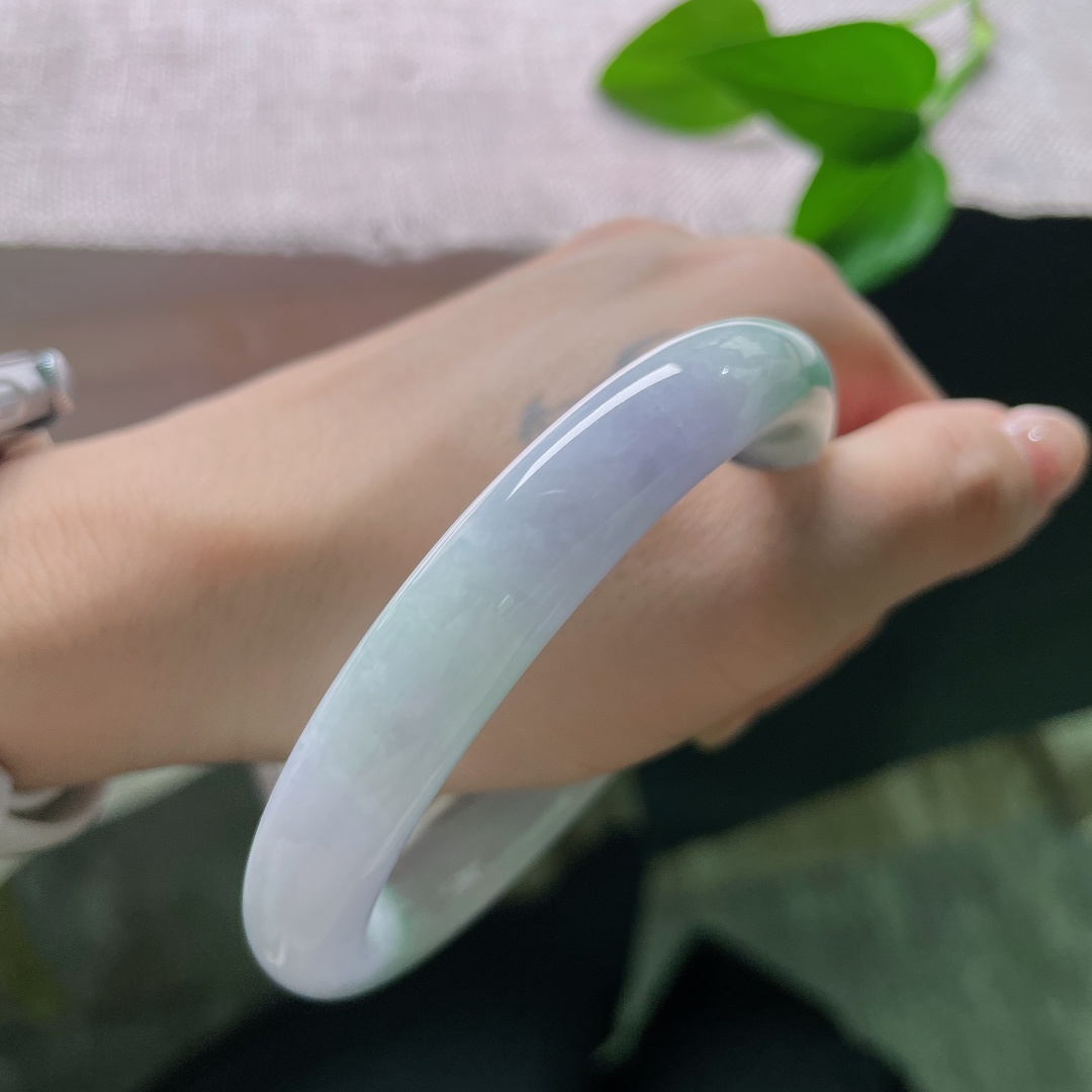 58/10，春彩圆条，一点裂，淡春底圆条玉镯，镯身弥漫一层淡淡的紫雾，浅浅揉入几分晴青底色，春韵温柔缱绻。ss57883a