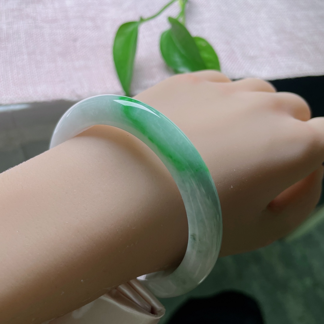 飘绿正圈，一点皮纹，镯身整体清润柔和，局部翠色若隐若现，留白干净，青绿点睛。ss57989a