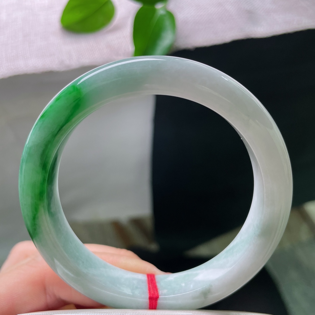 57/11.9/9.2，飘绿正圈，横纹，鲜亮的翠色集中于一隅，不漫天弥散，恰到好处成为整支镯子的点睛之笔，ss57985a