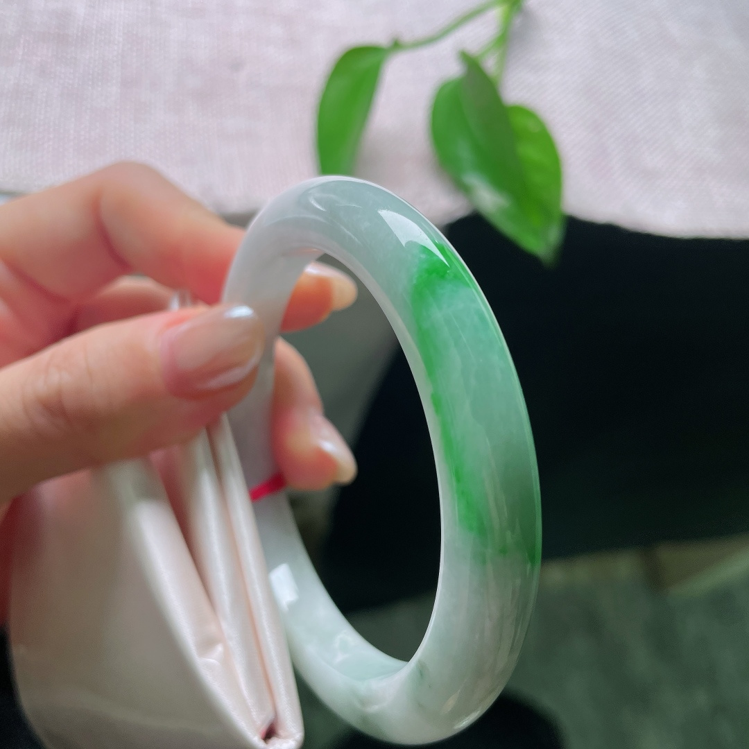 飘绿正圈，一点皮纹，镯身整体清润柔和，局部翠色若隐若现，留白干净，青绿点睛。ss57989a