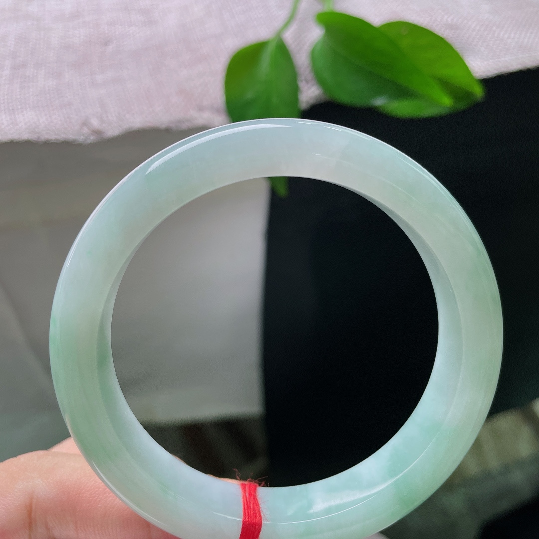 蓝底正圈，皮纹，清浅柔和的翠色缓缓晕染镯身，如春日湖面泛起的淡淡绿意，清爽怡人。ss57954a