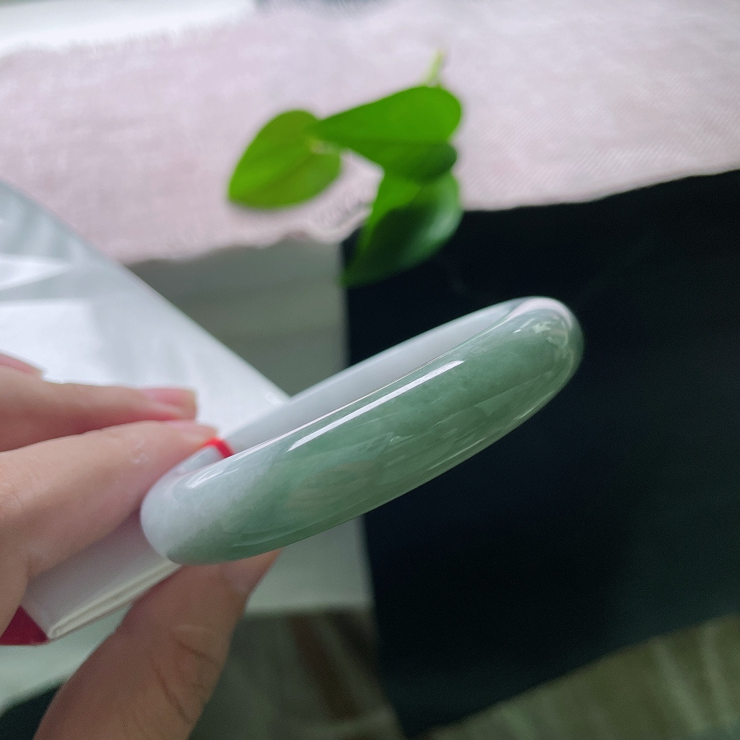 油青正圈，无裂，半山半水，一半素白清底，一半翠色凝润，玉色自然过渡，如山水画卷晕染在镯身之上。ss57913a