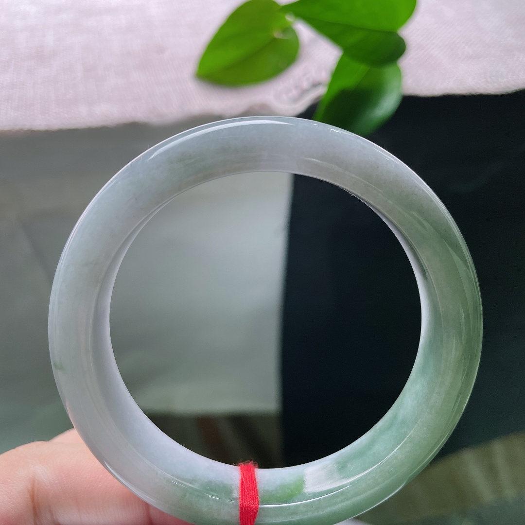 油青正圈，无裂，半山半水，一半素白清底，一半翠色凝润，玉色自然过渡，如山水画卷晕染在镯身之上。ss57913a