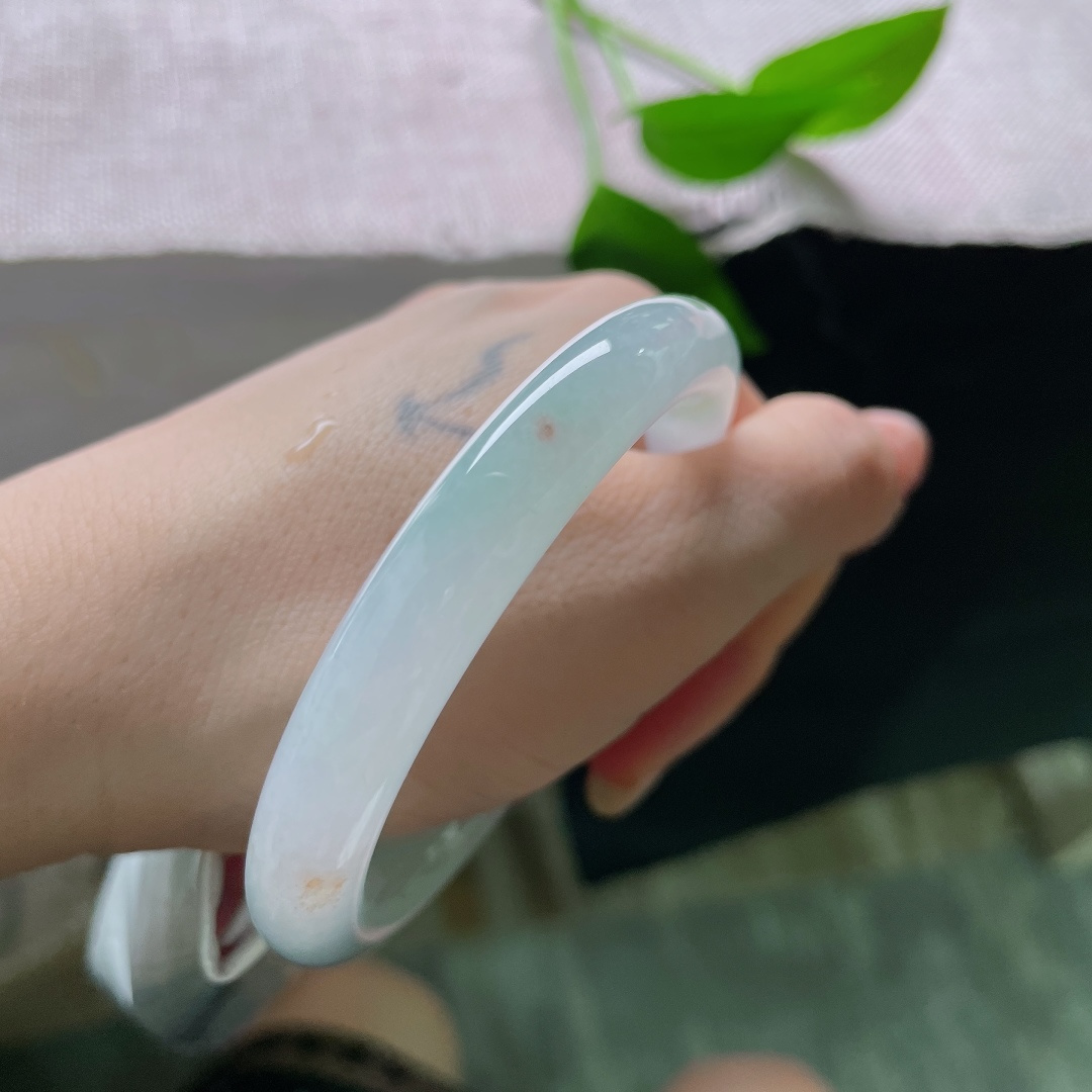绿底圆条，无裂，洒金，镯身晕染淡淡的浅晴底色，似山间晨雾漫过玉骨，清浅朦胧，自带一份悠然空灵的诗意。ss58341a
