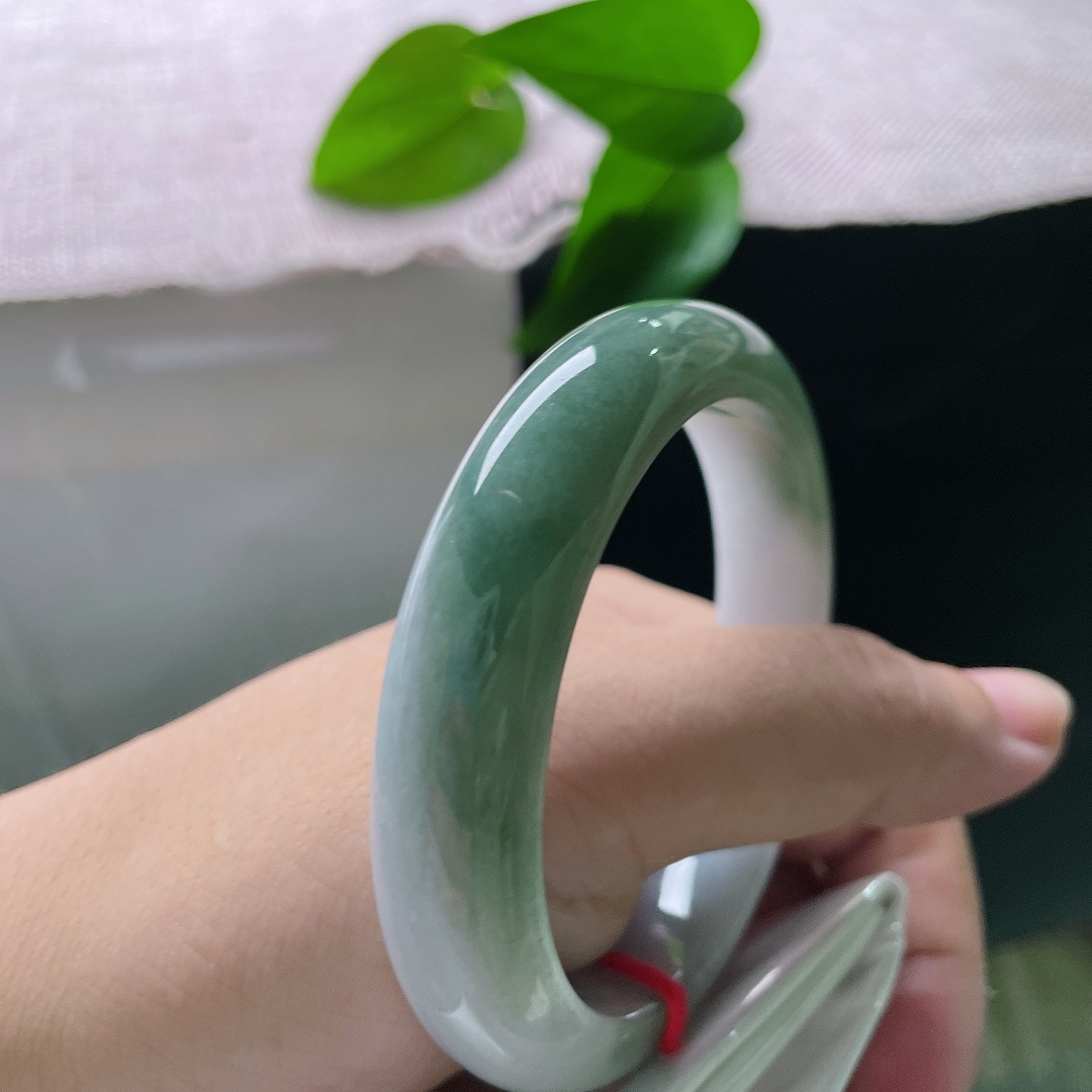 油青正圈，无裂，半山半水，一半素白清底，一半翠色凝润，玉色自然过渡，如山水画卷晕染在镯身之上。ss57913a