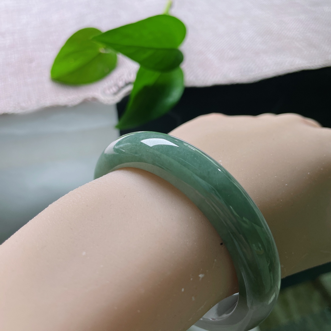 油青正圈，无裂，半山半水，一半素白清底，一半翠色凝润，玉色自然过渡，如山水画卷晕染在镯身之上。ss57913a