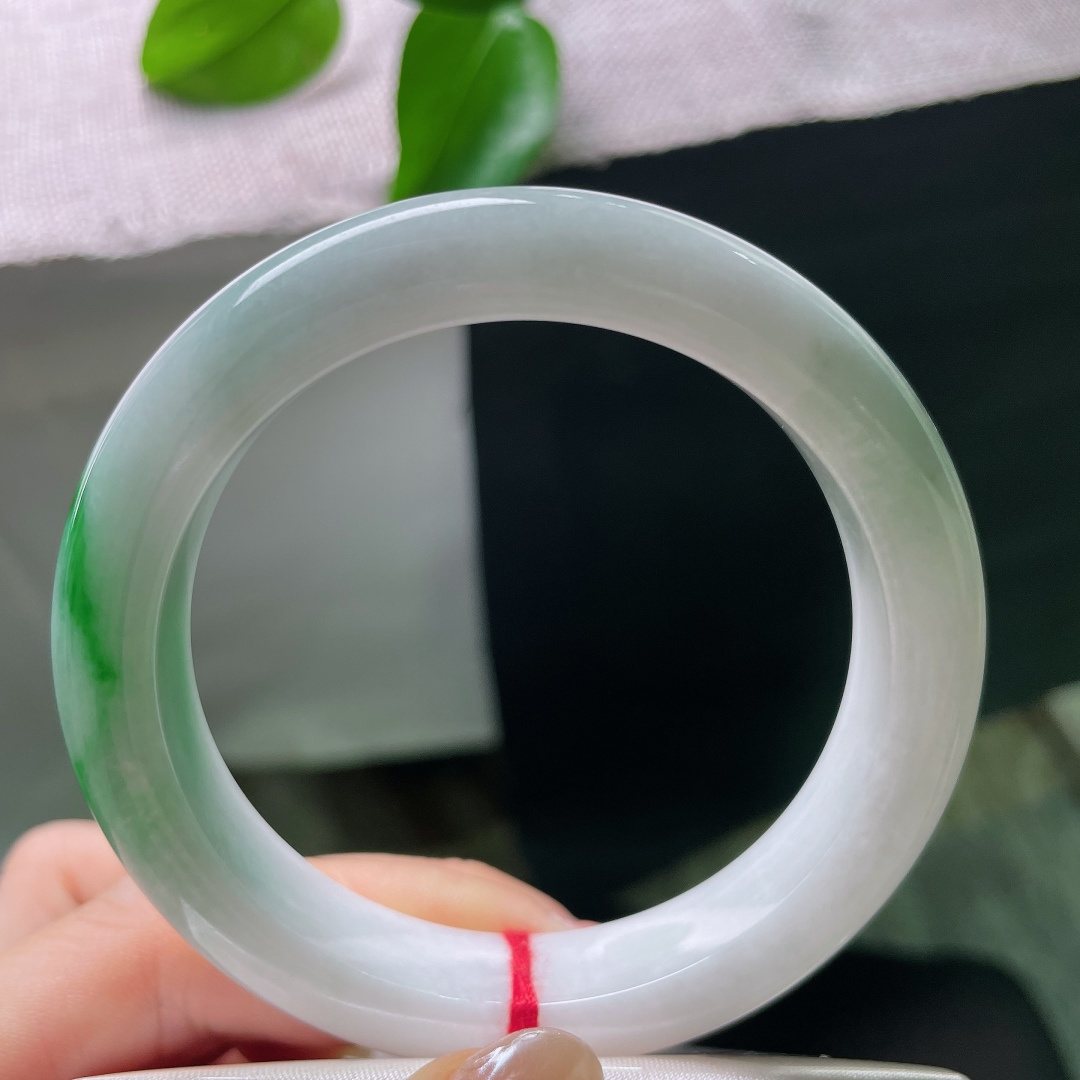 飘绿正圈，横纹，强烈和谐的色彩，清润白底沉静柔和，一抹辣绿热烈明媚，动静相融，是翡翠里经典耐看的国风款式。ss57977a