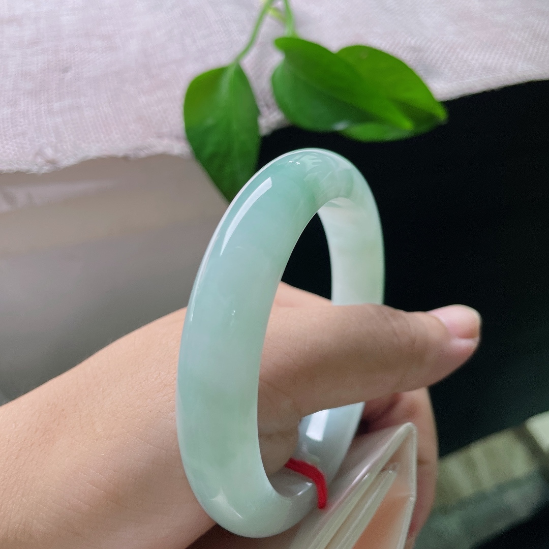 蓝底正圈，皮纹，清浅柔和的翠色缓缓晕染镯身，如春日湖面泛起的淡淡绿意，清爽怡人。ss57954a
