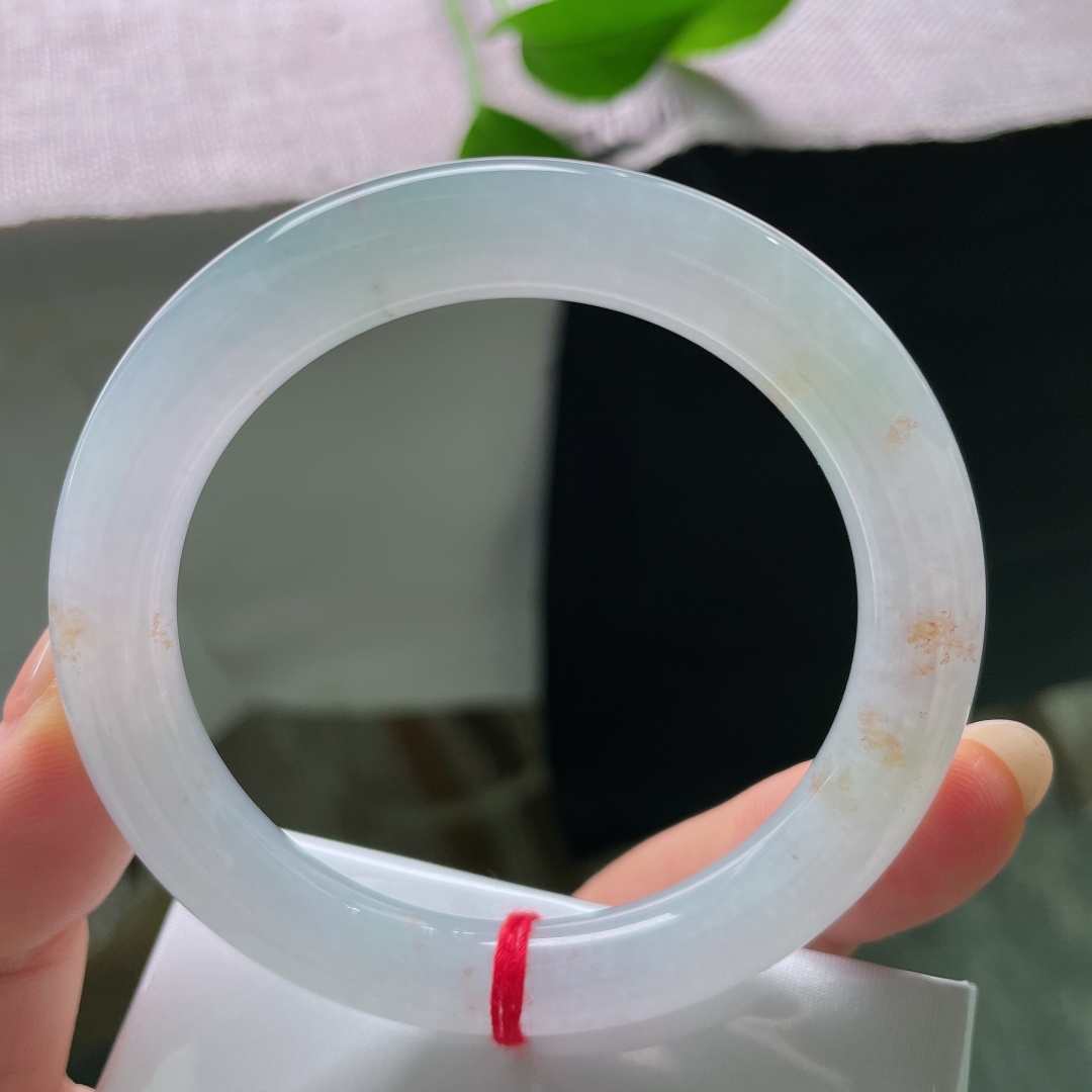 绿底圆条，无裂，洒金，镯身晕染淡淡的浅晴底色，似山间晨雾漫过玉骨，清浅朦胧，自带一份悠然空灵的诗意。ss58341a