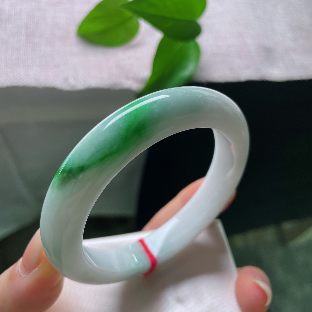 飘绿正圈，横纹，强烈和谐的色彩，清润白底沉静柔和，一抹辣绿热烈明媚，动静相融，是翡翠里经典耐看的国风款式。ss57977a