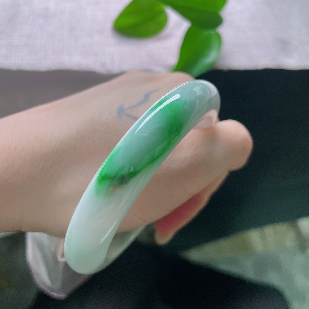 飘绿正圈，横纹，强烈和谐的色彩，清润白底沉静柔和，一抹辣绿热烈明媚，动静相融，是翡翠里经典耐看的国风款式。ss57977a