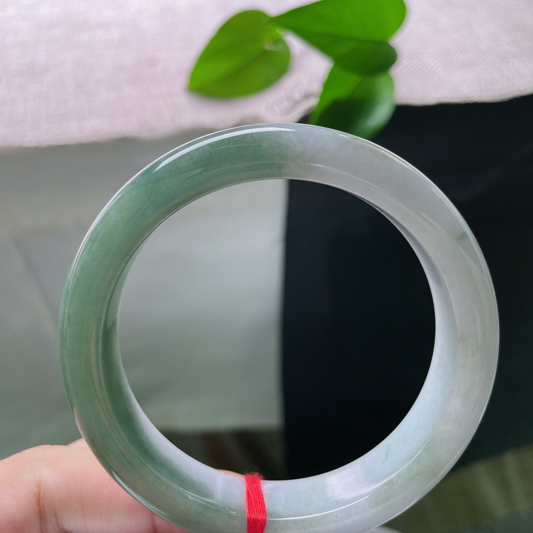 油青正圈，无裂，半山半水，一半素白清底，一半翠色凝润，玉色自然过渡，如山水画卷晕染在镯身之上。ss57913a