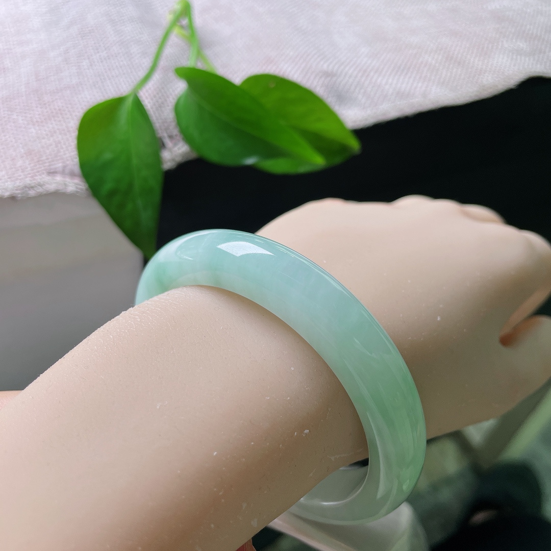 蓝底正圈，皮纹，清浅柔和的翠色缓缓晕染镯身，如春日湖面泛起的淡淡绿意，清爽怡人。ss57954a