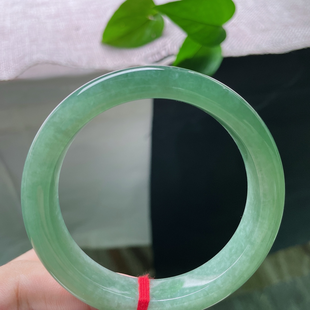 绿底正圈，无裂，玉质细腻通透，带着淡淡的胶感，镯面抛光亮润，水光柔和内敛。ss58282a