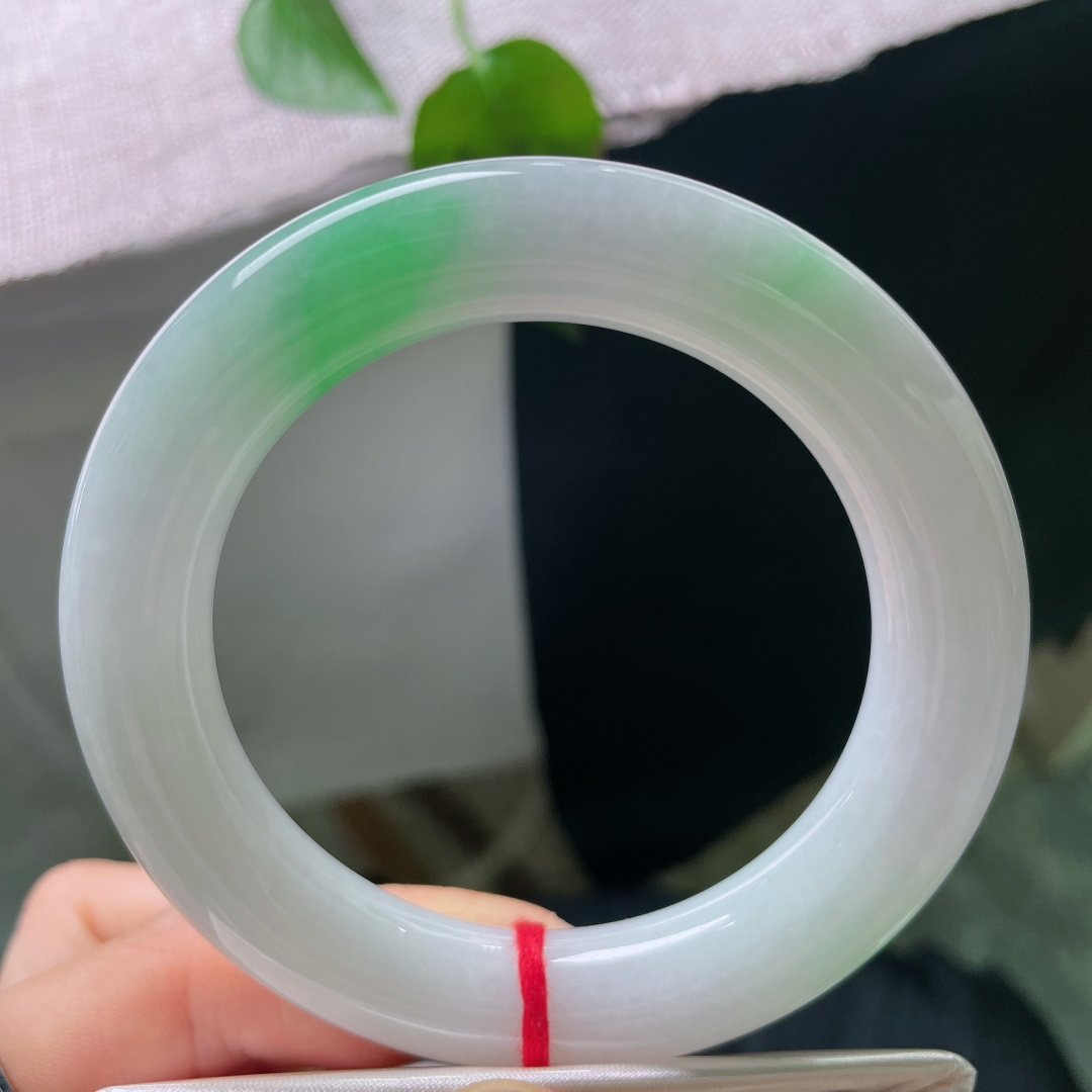 56/11.7，飘绿圆条，一点棉线，浅底飘一抹甜绿翡翠圆条，种水细腻柔和，翠色集中亮眼，复古镯型，衬