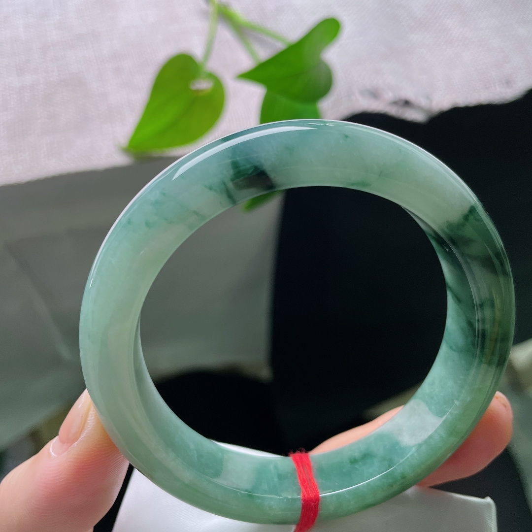 57/13/9.0，飘花正圈，一点皮纹，油绿飘花平安镯，深绿底色沉静温润，墨色飘花如浓墨入画，氛围感十足。ss56913a