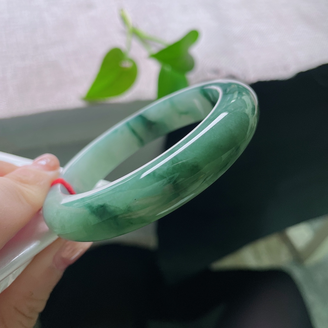 57/13/9.0，飘花正圈，一点皮纹，油绿飘花平安镯，深绿底色沉静温润，墨色飘花如浓墨入画，氛围感十足。ss56913a