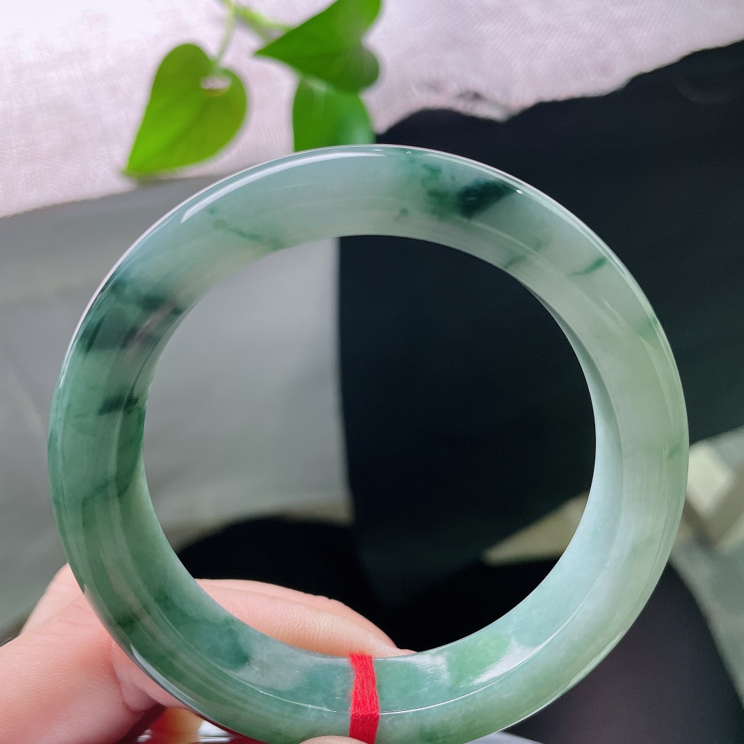 57/13/9.0，飘花正圈，一点皮纹，油绿飘花平安镯，深绿底色沉静温润，墨色飘花如浓墨入画，氛围感十足。ss56913a