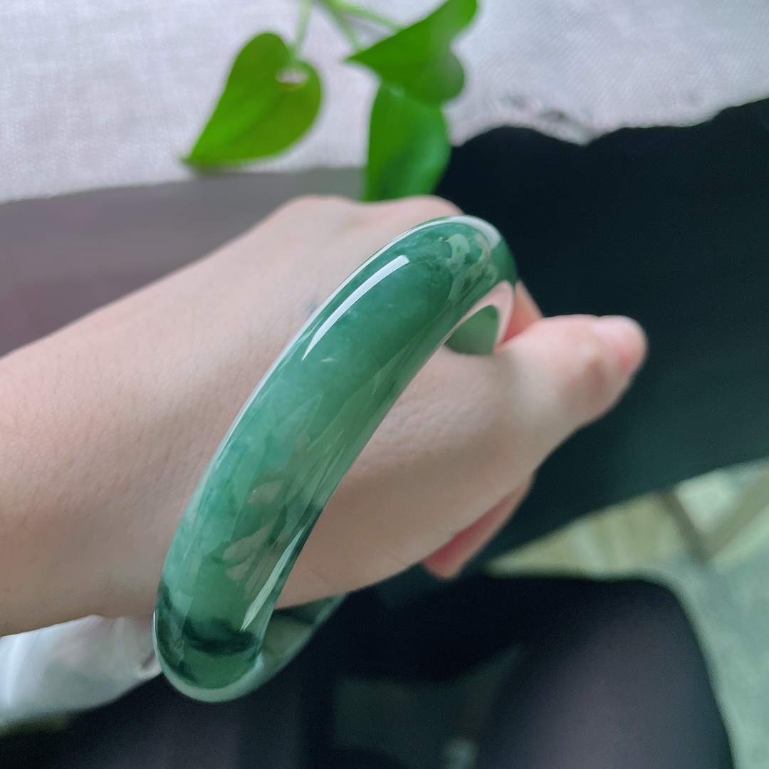 57/13/9.0，飘花正圈，一点皮纹，油绿飘花平安镯，深绿底色沉静温润，墨色飘花如浓墨入画，氛围感十足。ss56913a