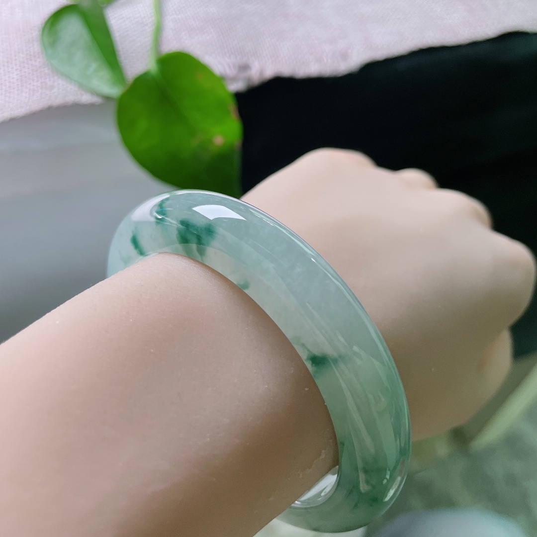 56.5/12.4/9.8，冰飘花正圈，无裂，冰底莹润起胶。浓淡相宜的蓝飘花随性晕染于镯身，似远山流墨，意境悠远灵动，花色分布错落有致不杂乱，极具韵味。ss58926a