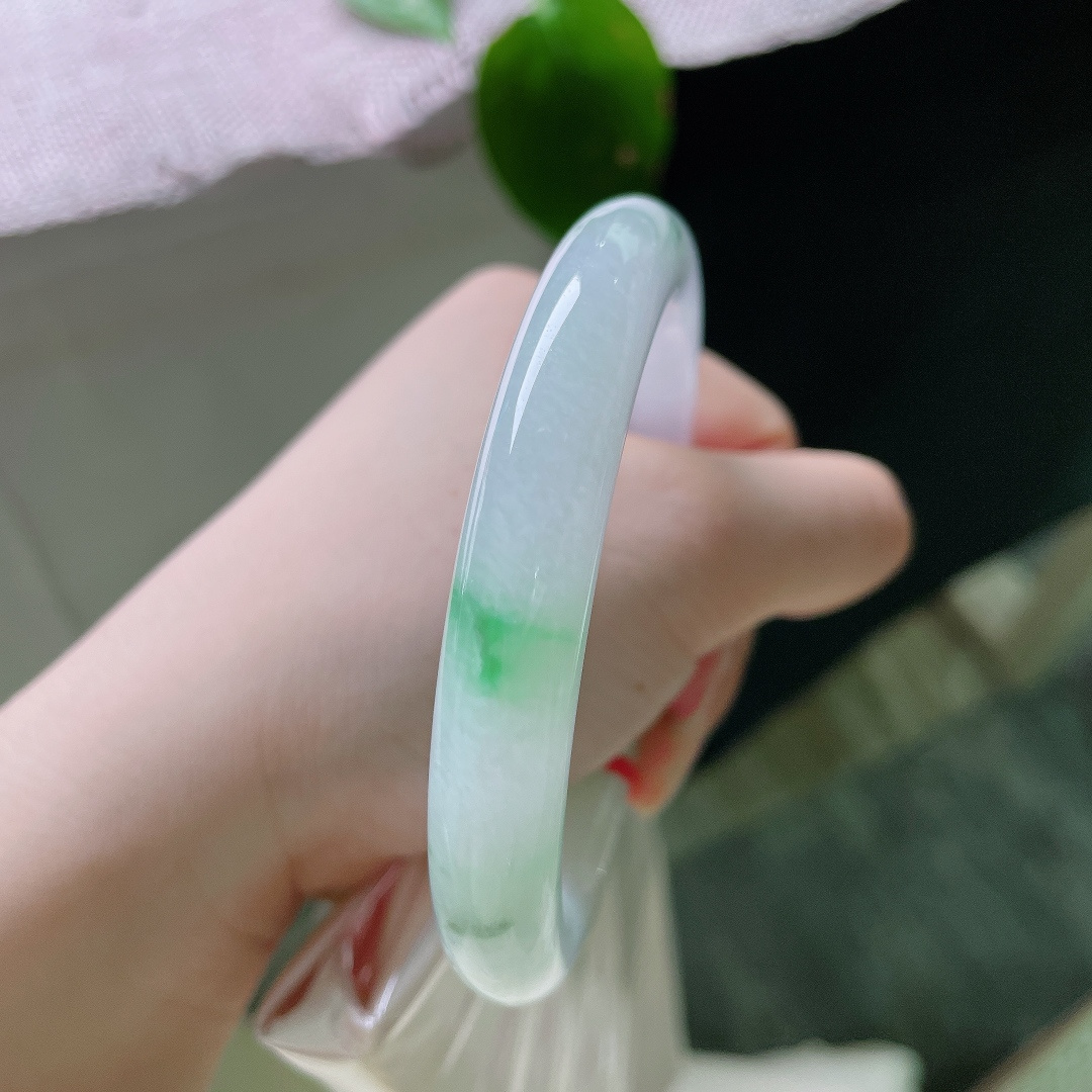 54.2/9.9，飘花圆条，无裂，素净玉底凝着几段鲜绿，浓淡相宜，灵气自生，温润雅致，将自然翠意凝于腕间。ss57317a