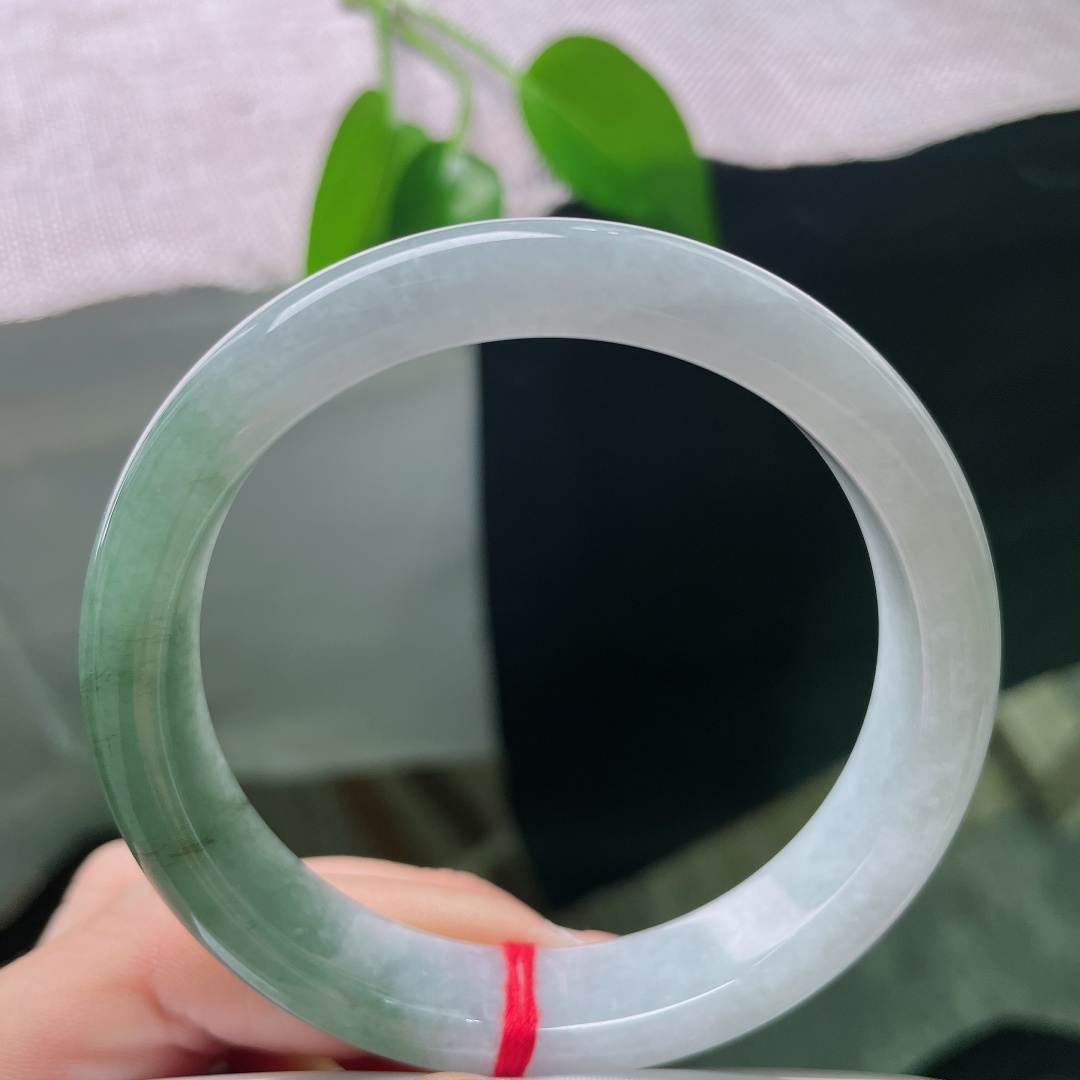 57.8/12.7/8，油青正圈，皮纹，白底与绿韵自然相融，如远山含碧水，一镯藏尽山水诗意。ss59006a