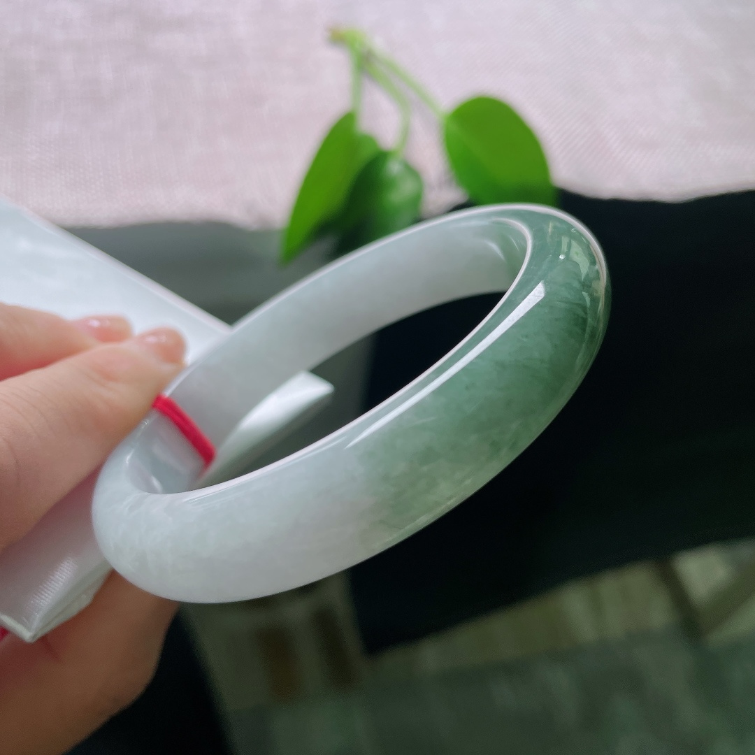 57.8/12.7/8，油青正圈，皮纹，白底与绿韵自然相融，如远山含碧水，一镯藏尽山水诗意。ss59006a