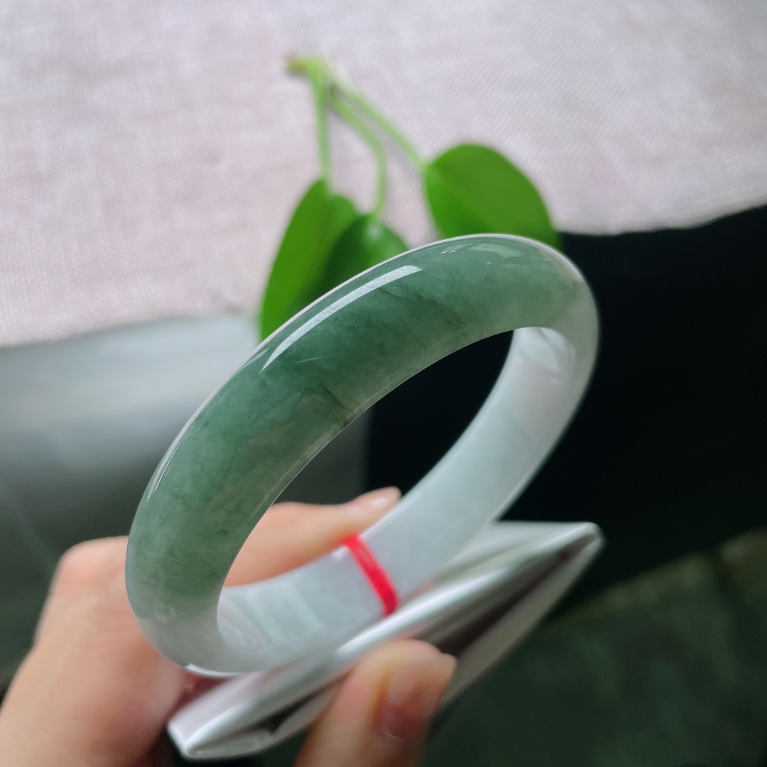 57.8/12.7/8，油青正圈，皮纹，白底与绿韵自然相融，如远山含碧水，一镯藏尽山水诗意。ss59006a