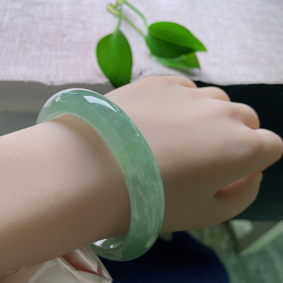 55.8/12.8/8.4，绿底正圈，皮纹，翠色温润均匀铺满镯身，种质细腻柔和，光泽内敛，佩戴衬得手腕清雅大气端庄。ss57894a