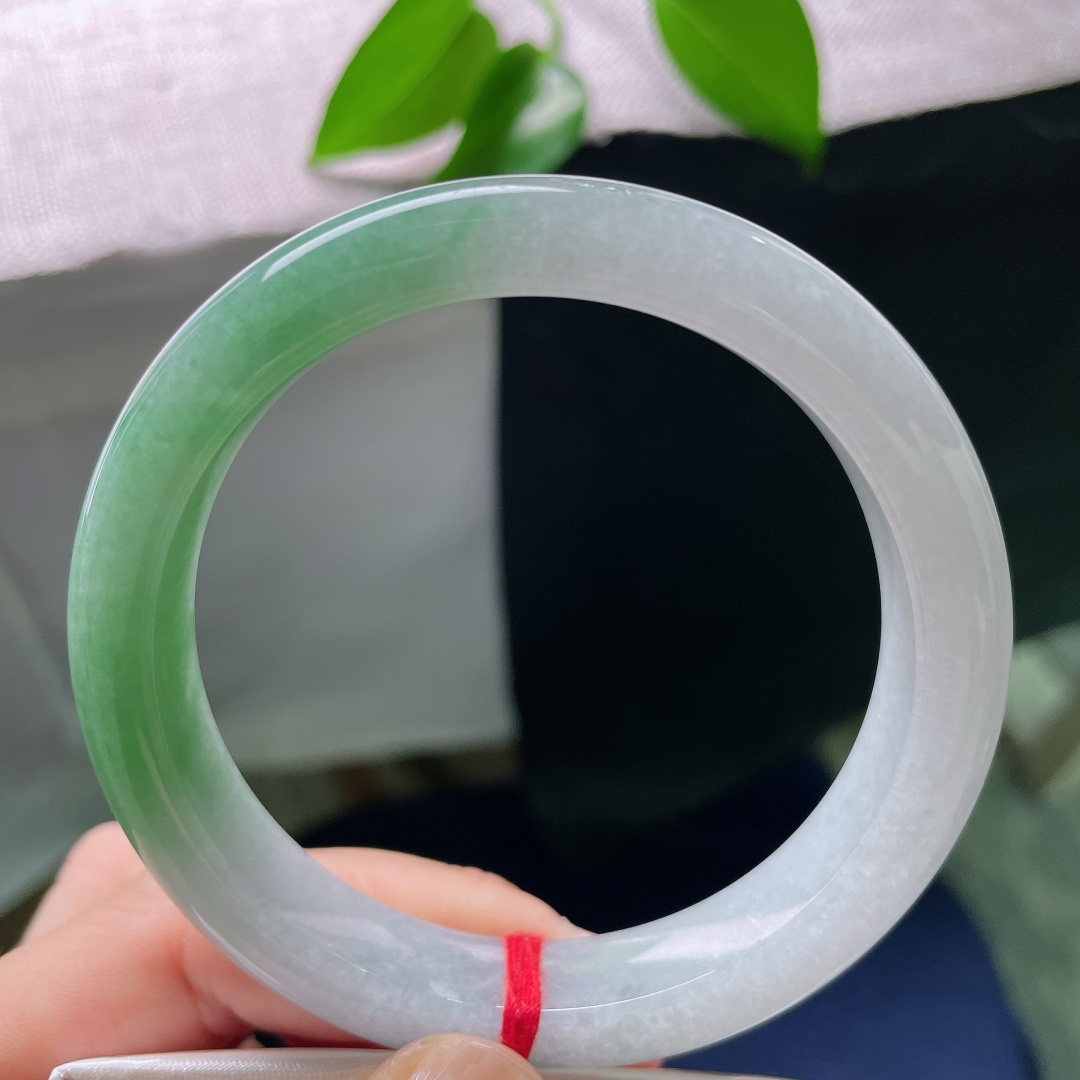 59/11.9/8.6，油青正圈，一点矿点，一镯两境，上半部分素净冰透，下半截晕染温润翠色，韵味十足。ss56766a