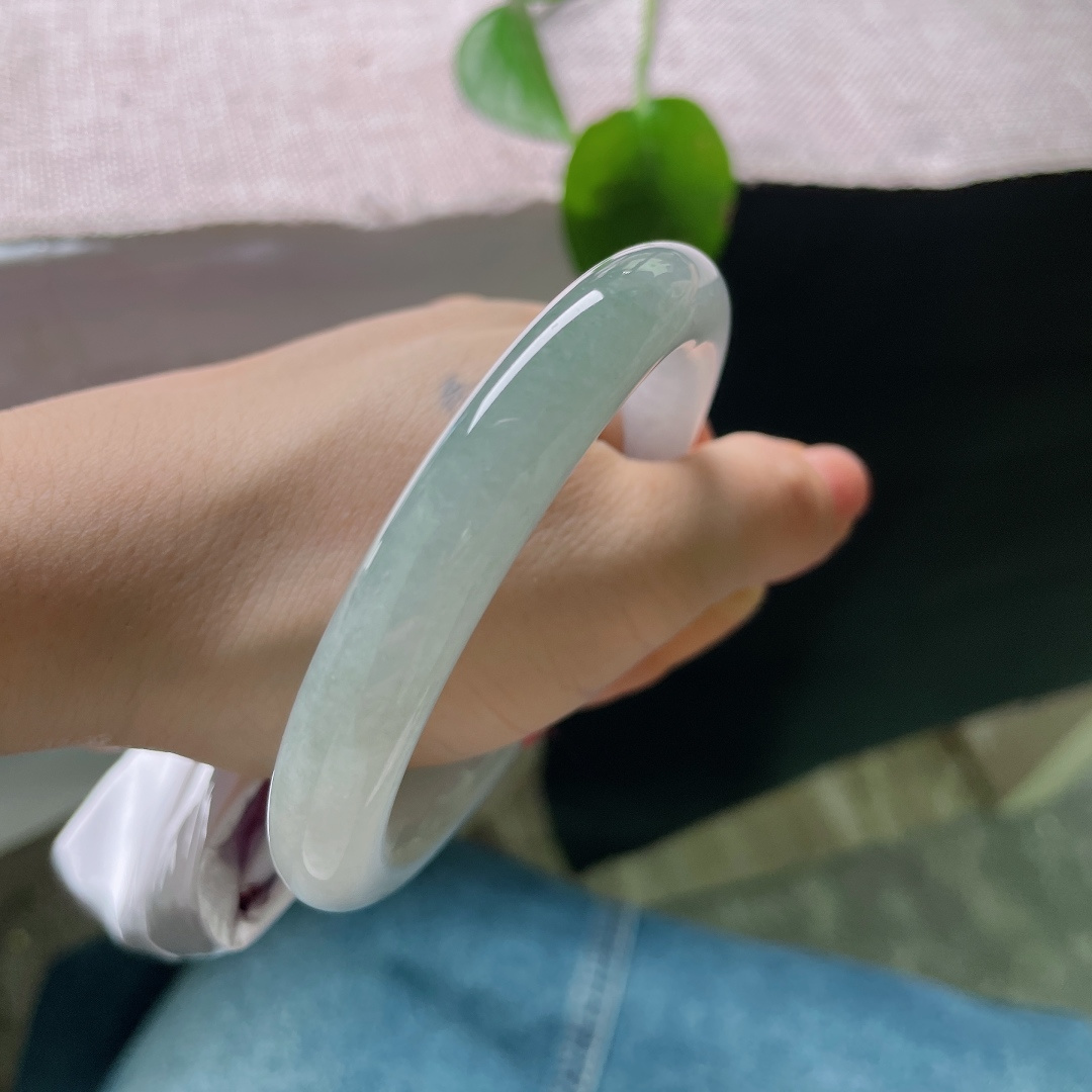 56.2/10.2，油青圆条，一点皮纹，冰润玉骨，色调由素白慢慢晕向青碧，水光盈盈，不喧不艳，于腕间藏住一山静水。ss59197a