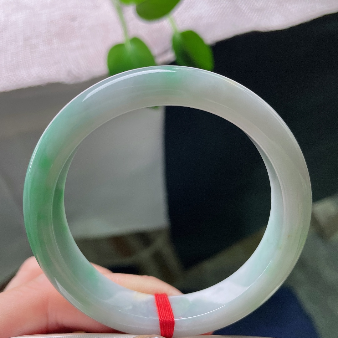 53.9/12.1/8.4，飘绿正圈，无裂，棉团，玉质细腻通透，数抹辣绿肆意晕染于镯身，色彩鲜亮，一眼便觉惊艳夺目。ss59323a