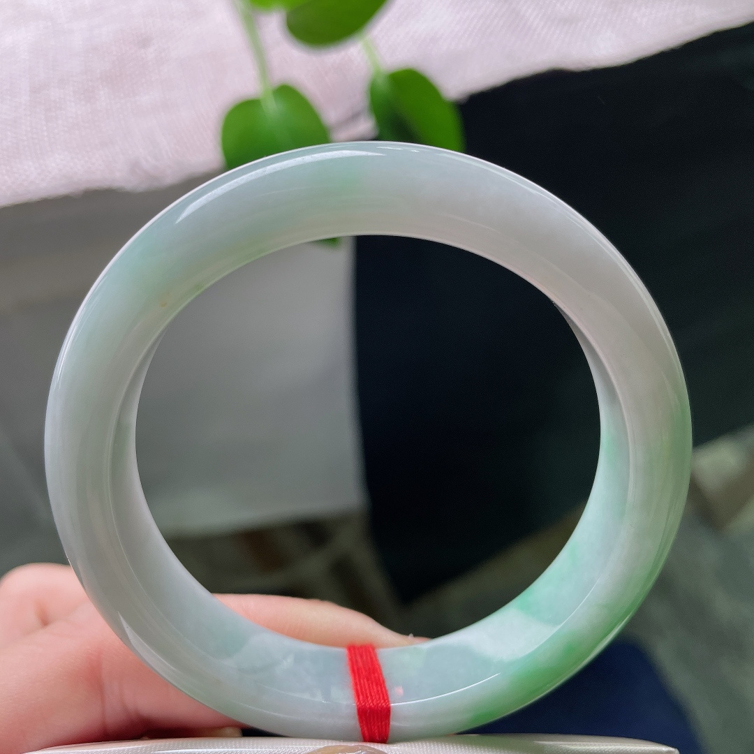 53.9/12.1/8.4，飘绿正圈，无裂，棉团，玉质细腻通透，数抹辣绿肆意晕染于镯身，色彩鲜亮，一眼便觉惊艳夺目。ss59323a