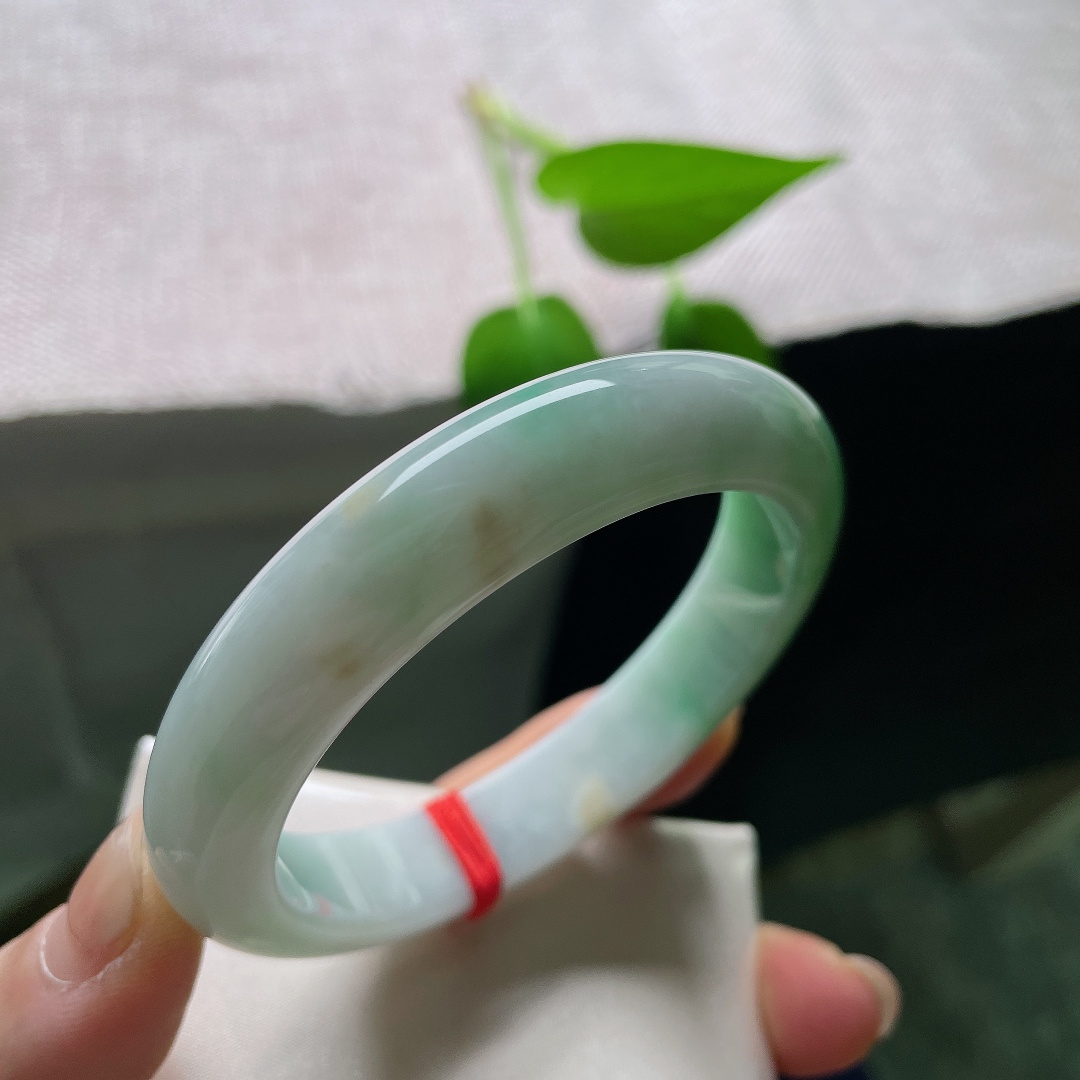 53.9/12.1/8.4，飘绿正圈，无裂，棉团，玉质细腻通透，数抹辣绿肆意晕染于镯身，色彩鲜亮，一眼便觉惊艳夺目。ss59323a