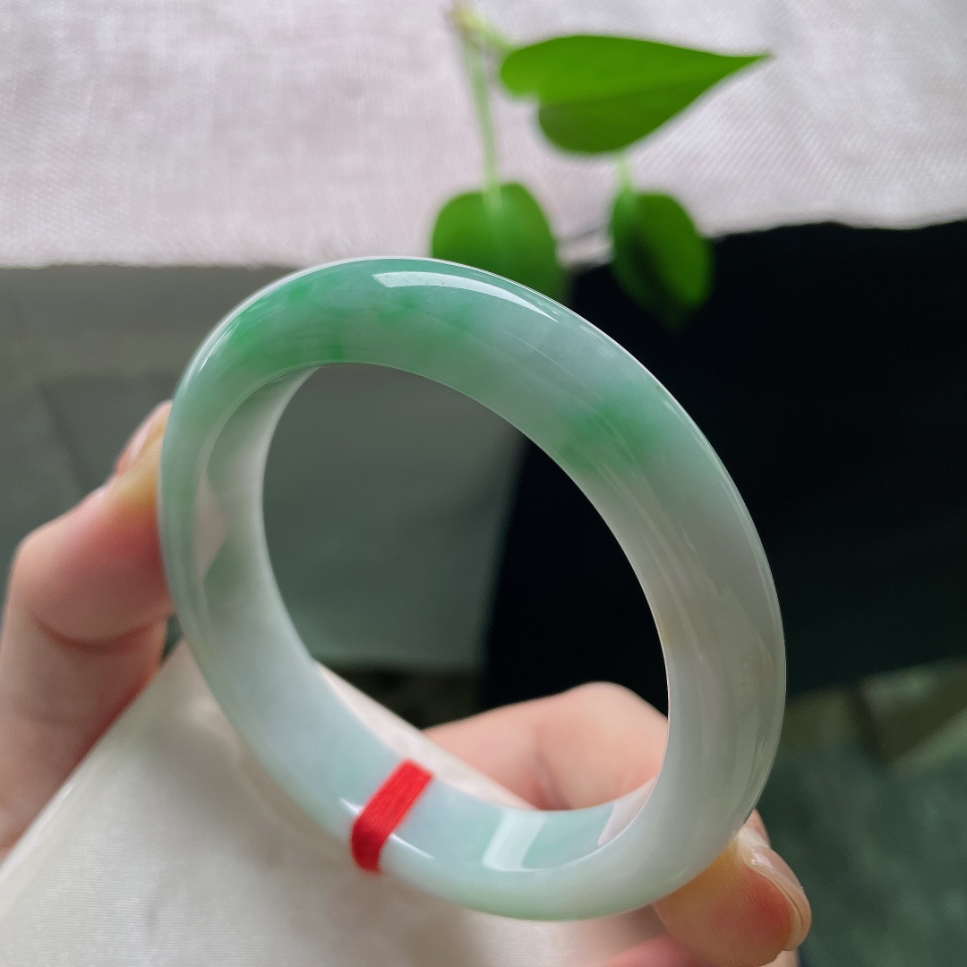 53.9/12.1/8.4，飘绿正圈，无裂，棉团，玉质细腻通透，数抹辣绿肆意晕染于镯身，色彩鲜亮，一眼便觉惊艳夺目。ss59323a
