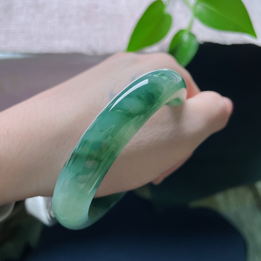 57.1/12.2/8.9，飘花正圈，一点皮纹，玉底冰润细腻，浓郁的墨绿飘花随性散落在镯身，自带古典的清冷气息，ss59413a