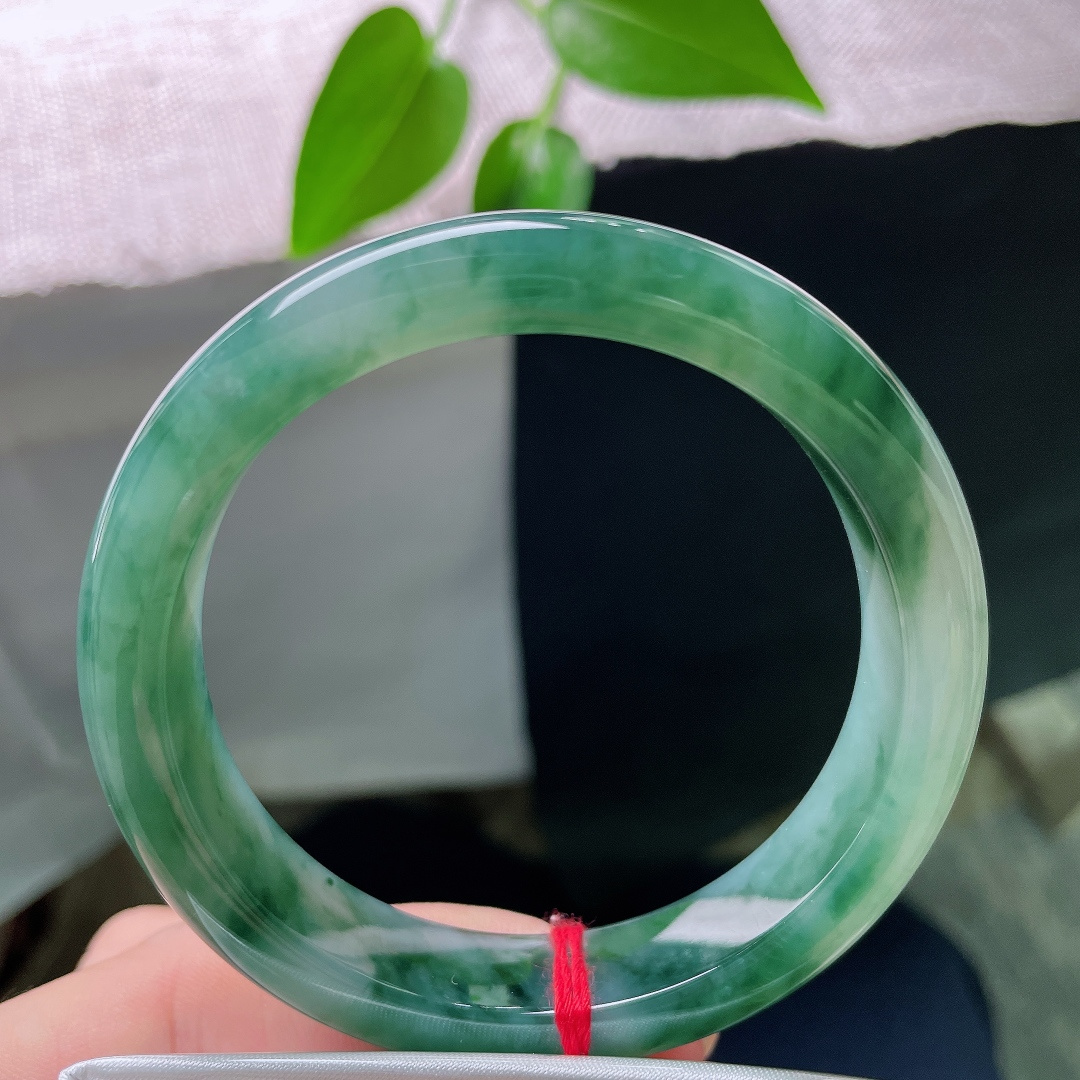 57.1/12.2/8.9，飘花正圈，一点皮纹，玉底冰润细腻，浓郁的墨绿飘花随性散落在镯身，自带古典